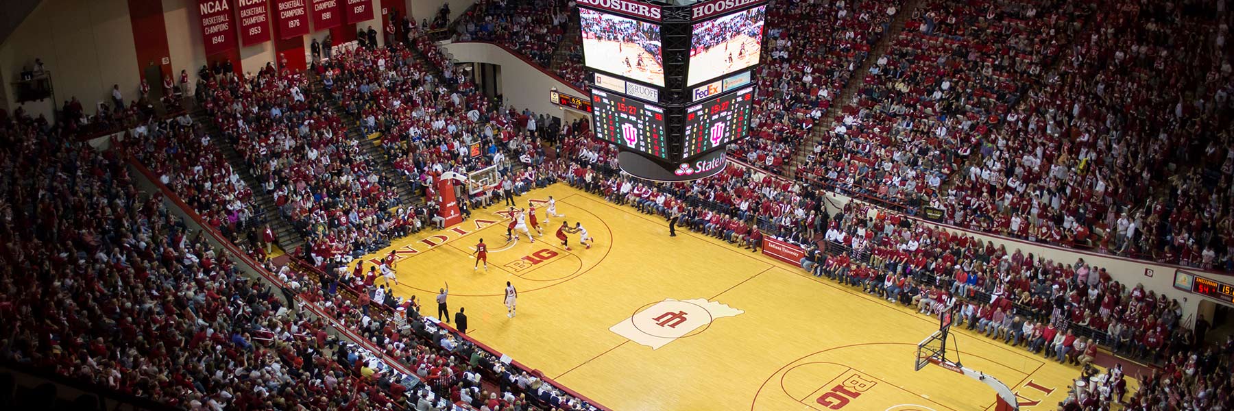 Stands filled with people wearing red and white at a basketball game.