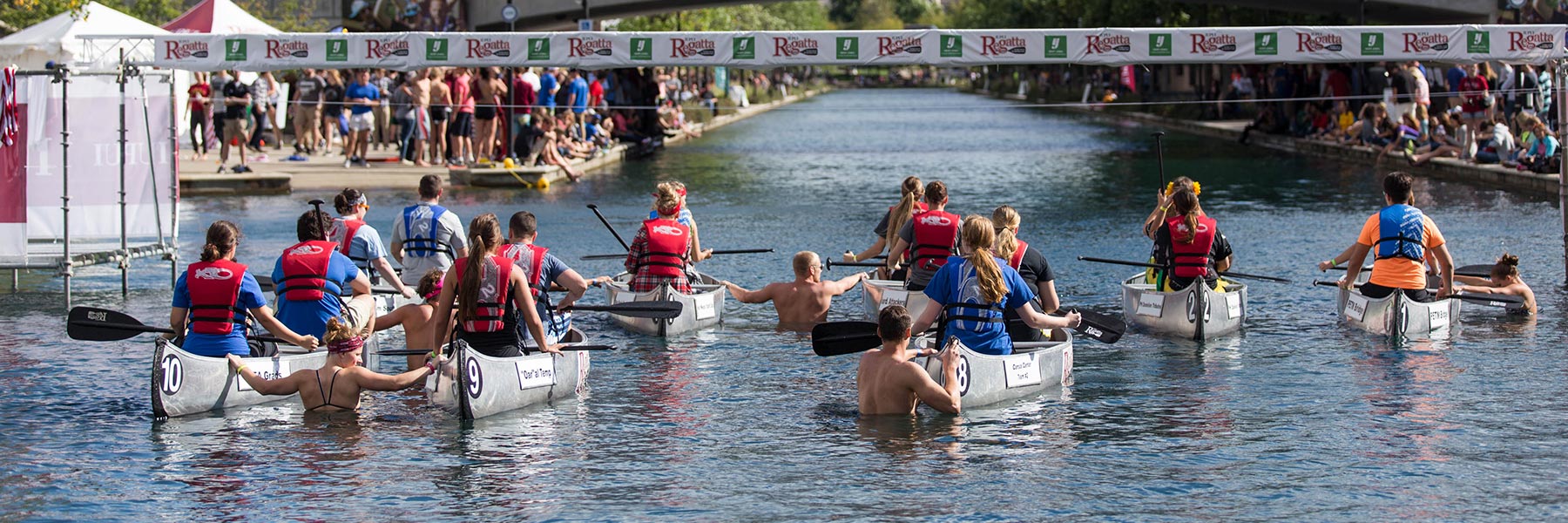 People wait with at the starting line with their canoes at the IUPUI Regatta